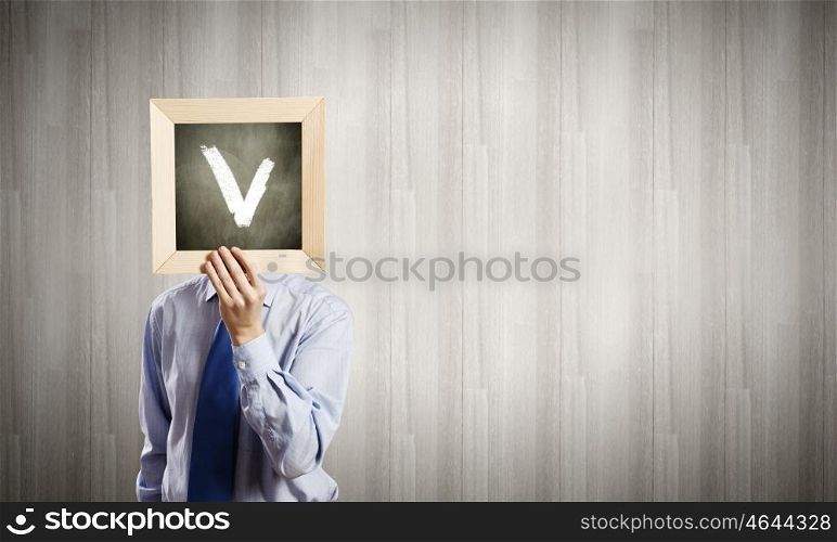Businessman with frame. Unrecognizable businessman holding wooden frame with tick mark