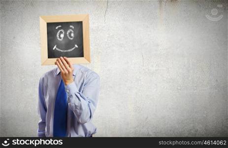 Businessman with frame. Young smiling businessman holding chalkboard with smiley