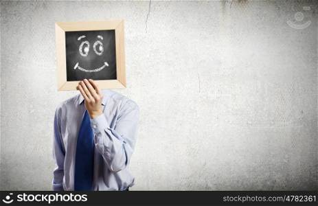 Businessman with frame. Young smiling businessman holding chalkboard with smiley