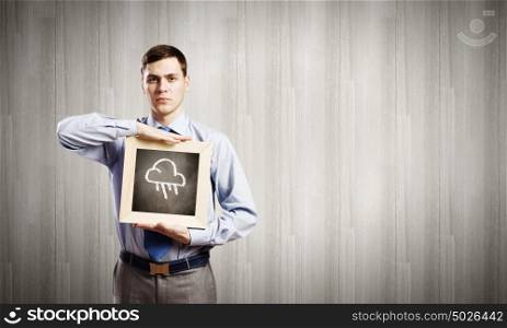 Businessman with frame. Young smiling businessman holding wooden frame with cloud sketch