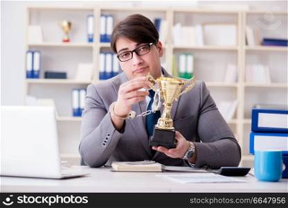 Businessman with golden cup in the office