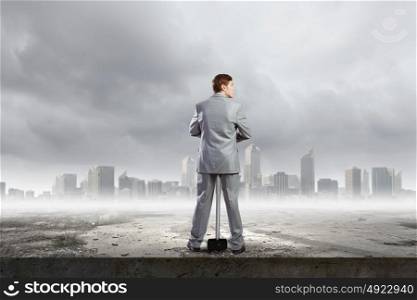 Businessman with hammer. Rear view of young determined businessman with big hammer in hands
