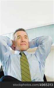 Businessman with hands behind his head