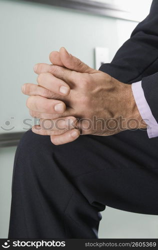 Businessman with hands clasped