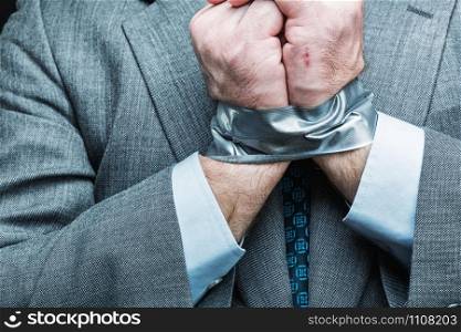 Businessman with hands covered by masking tape, studio shoot