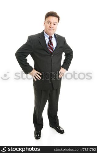 Businessman with hands on hips and a skeptical expression. Full body isolated.
