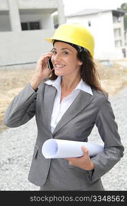 Businessman with helmet checking site under construction