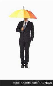 Businessman with hidden face under umbrella