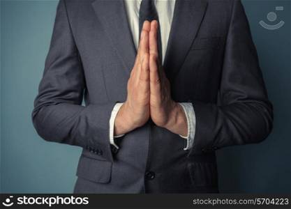 Businessman with his hands together in prayer