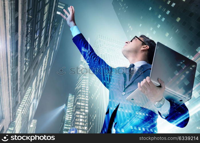 Businessman with laptop against the building