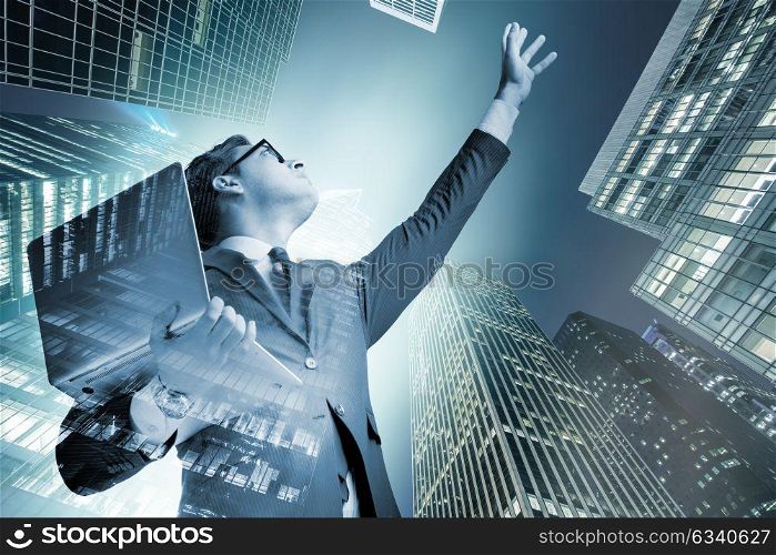 Businessman with laptop against the building