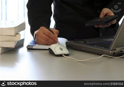Businessman with laptop and calculator