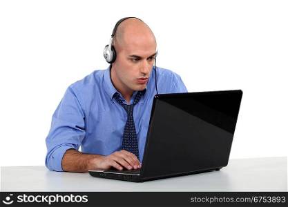 Businessman with laptop and headphones
