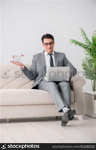 Businessman with laptop and shopping cart
