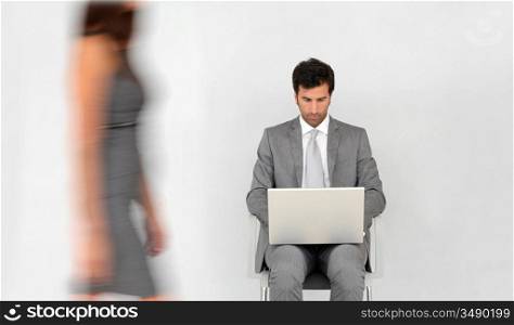 Businessman with laptop and woman passing by