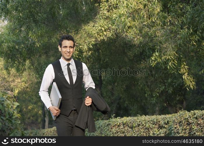 Businessman with laptop in a park , INDIA , DELHI