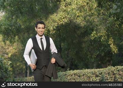 Businessman with laptop in a park , INDIA , DELHI