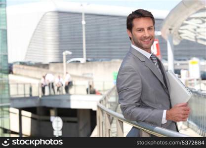Businessman with laptop outside