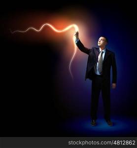 Businessman with light shining. Young successful businessman holding a shining light in his hand as a symbol of success and advancement.