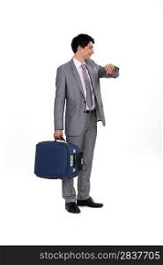 businessman with luggage consulting his watch