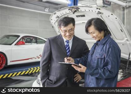 Businessman with Mechanic in Auto Repair Shop