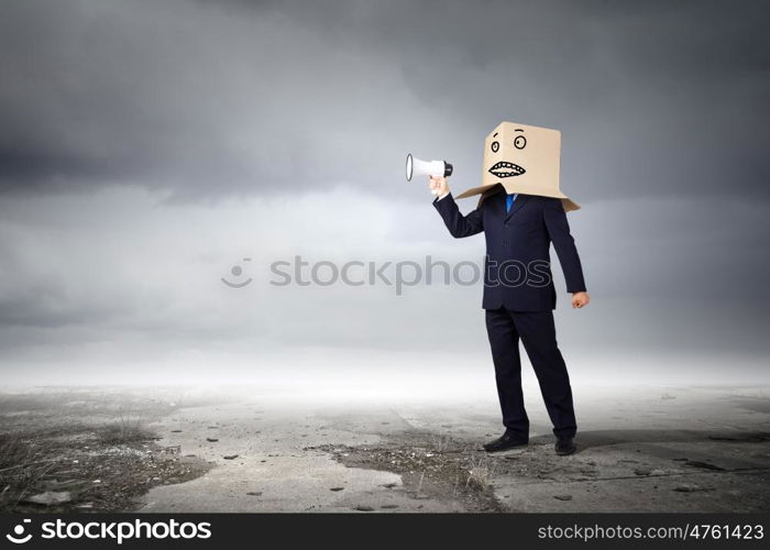 Businessman with megaphone. Businessman with box on head screaming in megaphone