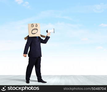 Businessman with megaphone. Businessman with box on head screaming in megaphone