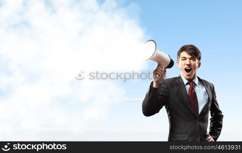 businessman with megaphone. young businessman in black suit screaming into megaphone