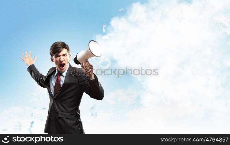 businessman with megaphone. young businessman in black suit screaming into megaphone