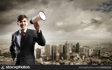 businessman with megaphone. young businessman smiling in black suit holding megaphone