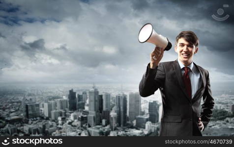 businessman with megaphone. young businessman smiling in black suit holding megaphone