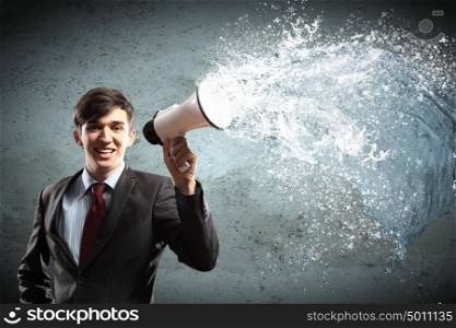 businessman with megaphone. young businessman smiling in black suit holding megaphone