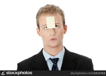 Businessman with memo stick message notes on forehead, over white studio background