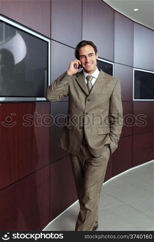 Businessman with mobile phone in front of modern building