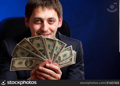 Businessman with money over blue background