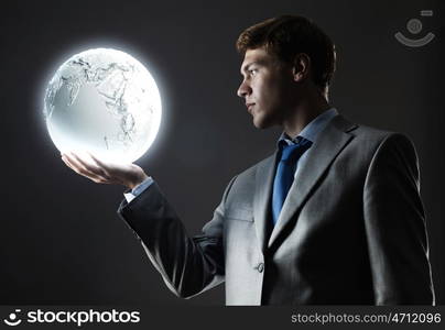 Businessman with moon. Young businessman holding moon planet in hand