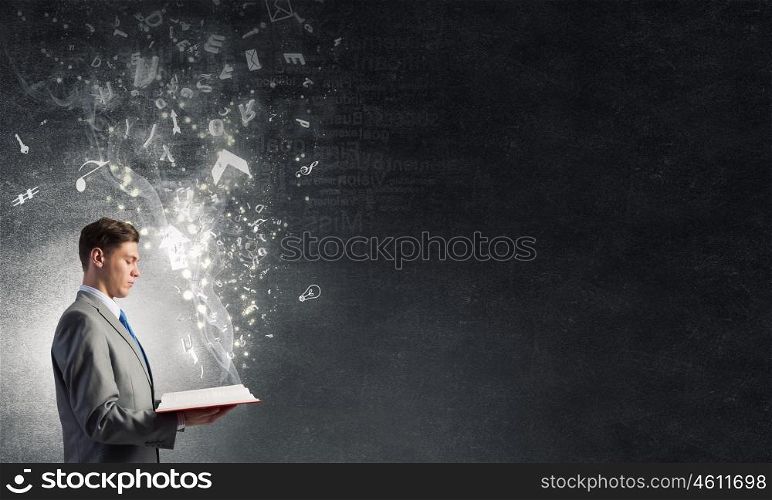 Businessman with opened book. Close up of man holding opened book with flying out characters