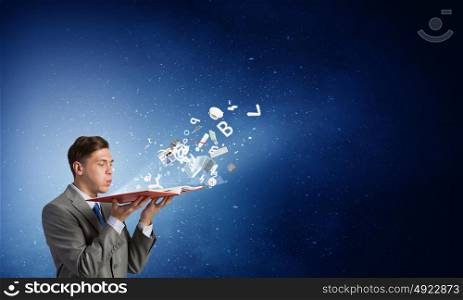 Businessman with opened book. Close up of man holding opened book with flying out characters