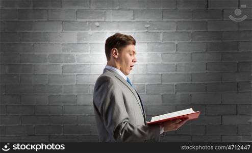 Businessman with opened book. young businessman holding opened book and light on pages