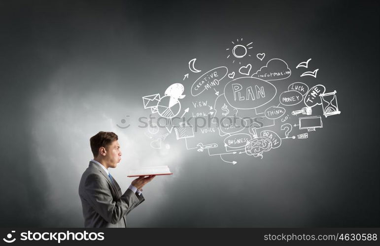 Businessman with opened book. Young businessman with opened book and plan sketches from pages