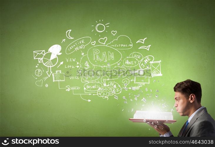 Businessman with opened book. Young businessman with opened book and plan sketches from pages