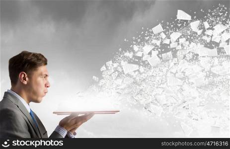 Businessman with opened book. Young businessman with opened book in hands and pages flying in air