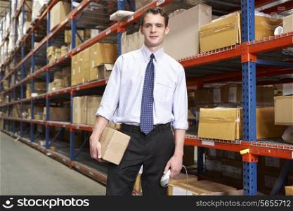 Businessman With Package And Scanner In Warehouse