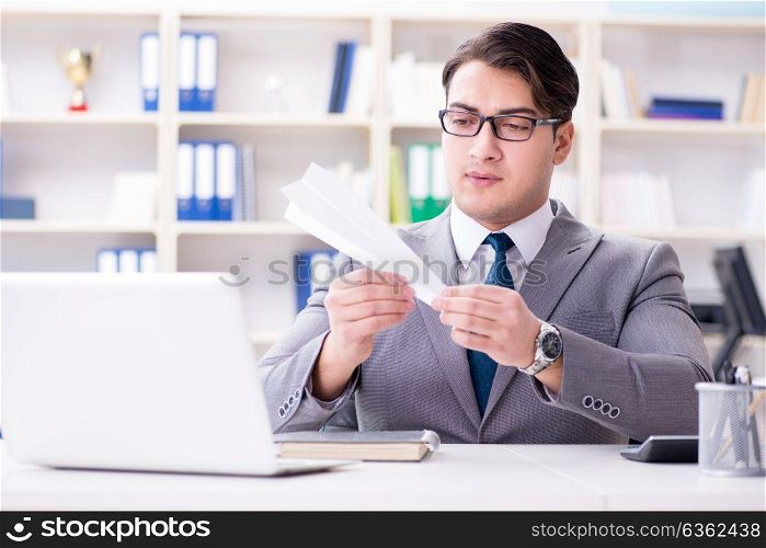 Businessman with paper airplane in office