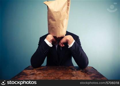 Businessman with paper bag over his head