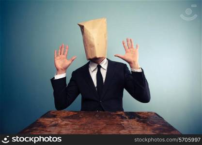 Businessman with paper bag over his head is shocked