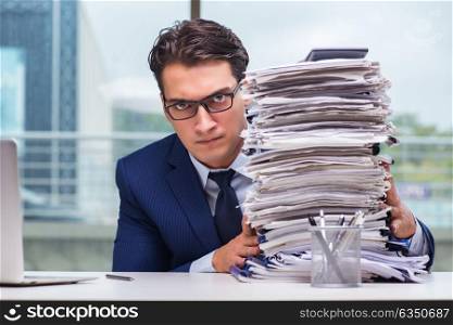 Businessman with pile stack of paper paperwork in the office