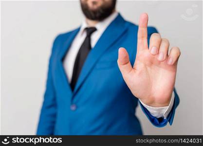 Businessman with pointing finger in front of him.. Businessman with pointing finger in front of him. Businessman holds lap top in hand and points with his finger.
