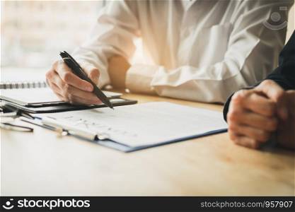 Businessman with pointing to paper about to sign a contract after successful agreement.