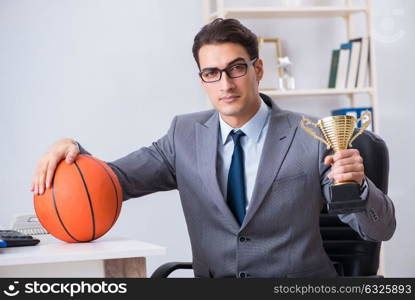 Businessman with prize cup for achievements in office